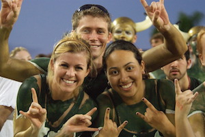 Ƶstudents at football game in green and gold paint.